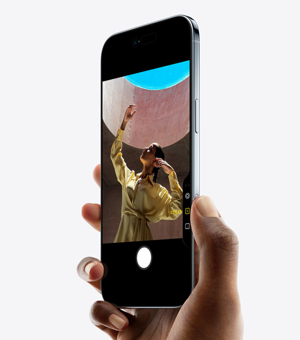 Une main tenant un iPhone Air avec le pouce sur le bouton Commande de l’appareil photo, face avant, côté, profil fin, Dynamic Island, bouton latéral