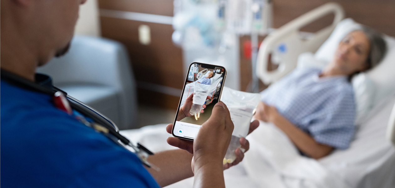 Un infirmier scanne les médicaments d’une personne prise en charge.